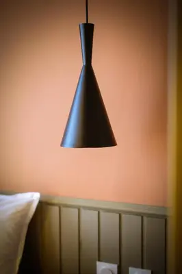a black light hanging from a wall above a bed at Beautiful best location apartment Red Mouse in Plovdiv