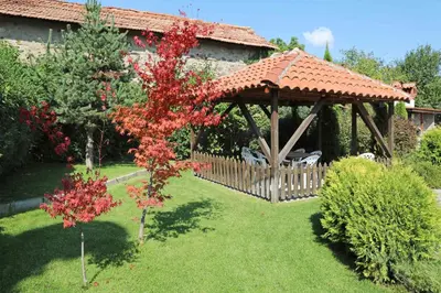 a wooden gazebo in the yard of a house at guest house Margarita in Bryagovo