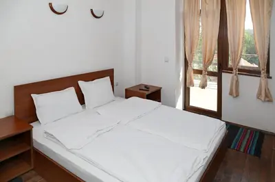 a bedroom with a bed with white sheets and a window at guest house Margarita in Bryagovo