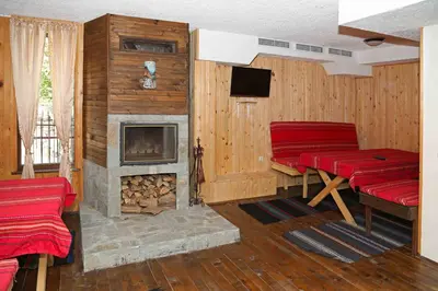 a living room with red chairs and a fireplace at guest house Margarita in Bryagovo
