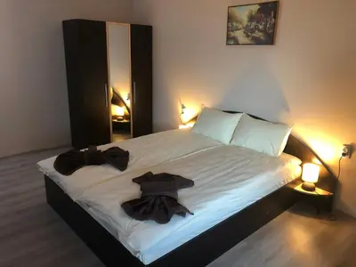a bedroom with a bed with two black towels on it at Vila Rila in Sapareva Banya
