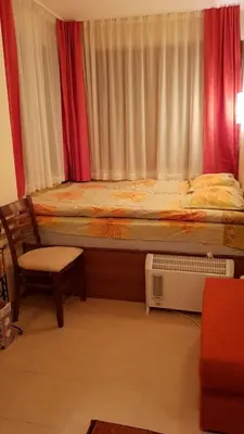 a bedroom with a bed and a chair and a window at Cozy Studio in Mountain Lake Complex Smolyan Pamporovo in Smolyan
