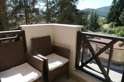 a balcony with wicker chairs and a view of a mountain at Апартамент Мия Deluxe in Velingrad