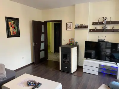 a living room with a flat screen tv and a living room with a couch at Апартамент Мия Deluxe in Velingrad