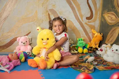 a little girl sitting next to a bunch of stuffed animals at Katalina Resort in Tsigov Chark