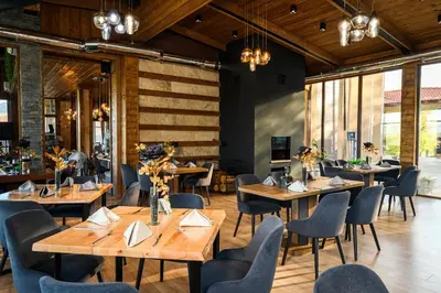 a restaurant with wooden tables and chairs at Katalina Resort in Tsigov Chark