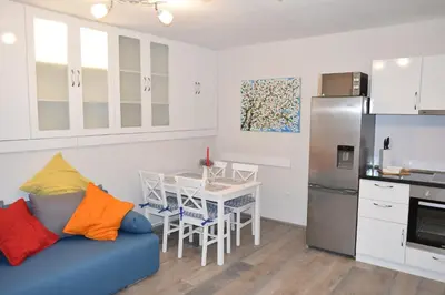 a kitchen with a blue couch and a table with chairs at SWEET HOME PLOVDIV in Plovdiv