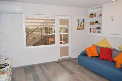 a living room with a blue couch and a window at SWEET HOME PLOVDIV in Plovdiv