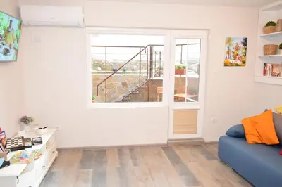 a living room with a blue couch and a window at SWEET HOME PLOVDIV in Plovdiv