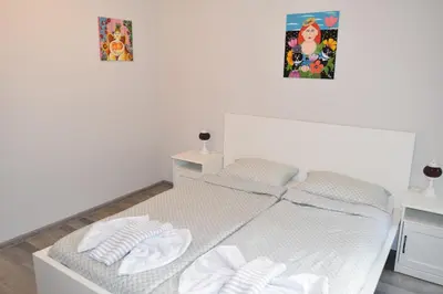 a white bed with two white towels on it at SWEET HOME PLOVDIV in Plovdiv