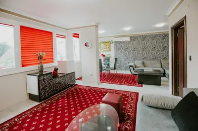 a living room with red walls and a red rug at Dimitrovi Rooms in Sofia