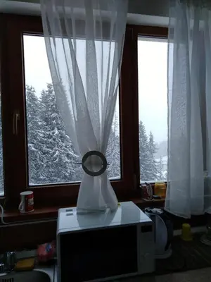 a television sitting on a table in front of a window at Пампорово Студио М хотел в Росица in Pamporovo