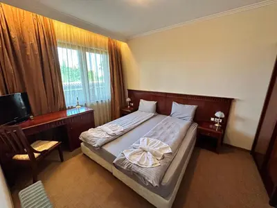 a bedroom with a bed and a desk and a television at Downtown Luxury private apartments in Bansko