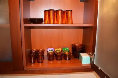a cupboard with a bunch of brown cups in it at Downtown Luxury private apartments in Bansko
