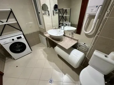 a bathroom with a toilet sink and a washing machine at Downtown Luxury private apartments in Bansko