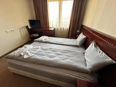 two beds in a hotel room with a window at Downtown Luxury private apartments in Bansko