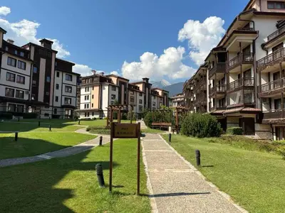 a group of buildings with a sign in the grass at Downtown Luxury private apartments in Bansko