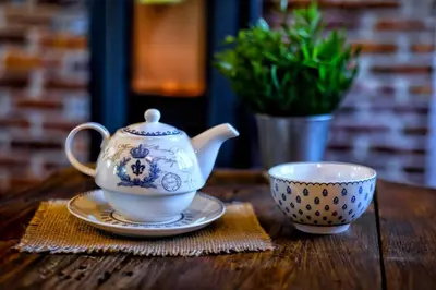 a tea pot and a cup on a wooden table at Вила Приказка in Tsar Kaloyan