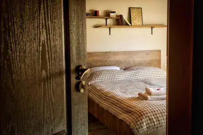 a bedroom with a wooden bed with towels on it at Вила Приказка in Tsar Kaloyan
