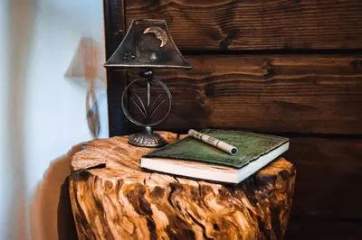 a lamp and a book and a pen on a table at Вила Приказка in Tsar Kaloyan