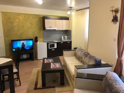 a living room with a couch and a table and a kitchen at Apartment 507 The Castle 1 in Pamporovo