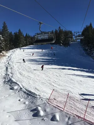 a group of people skiing down a snow covered ski slope at Apartment 507 The Castle 1 in Pamporovo