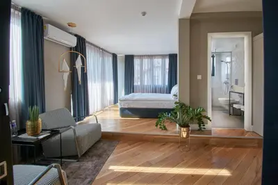 a bedroom with a bed and a living room at The Embassy Suites in Sofia