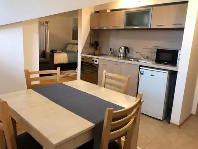 a kitchen and dining room with a table and a room at Stylish Studio Apart Aspen Golf Resort in Razlog