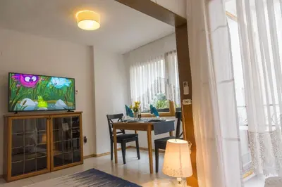 a living room with a dining table and a television at Аpartment Gem in Centre of Sandanski in Sandanski
