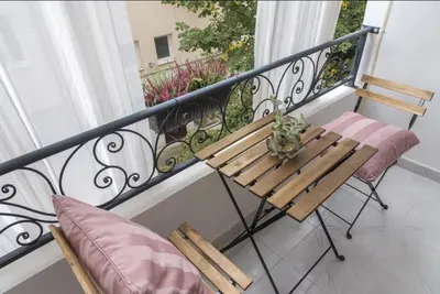 a balcony with a wooden table and two chairs at Аpartment Gem in Centre of Sandanski in Sandanski