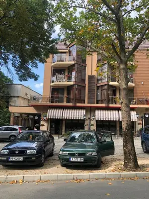 two cars parked in a parking lot in front of a building at Fantasy Apartment 15 комплекс Фантазия, Хисаря in Hisarya