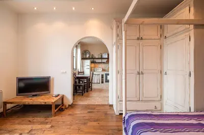 a bedroom with a bed and a tv and a table at Kings Park Boutique Apartment in Sofia