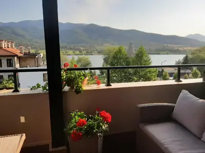 a balcony with a couch and a view of the water at Studio- apartament Lake View Pravets Golf Resort in Pravets