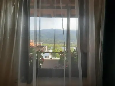 a window with a view of a house at Studio- apartament Lake View Pravets Golf Resort in Pravets
