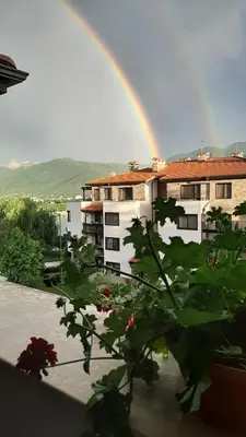 a rainbow in front of a building with a plant at Studio- apartament Lake View Pravets Golf Resort in Pravets