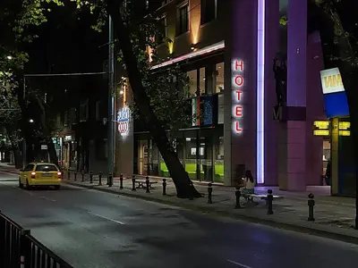 a car is driving down a city street at night at Hotel Puldin COOP in Plovdiv