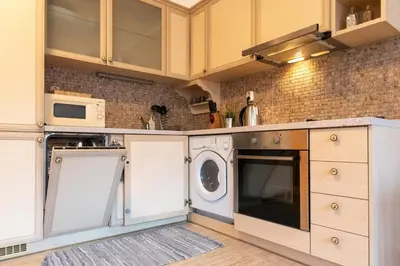 a kitchen with white cabinets and a washer and dryer at Studio Talisman II in Sofia
