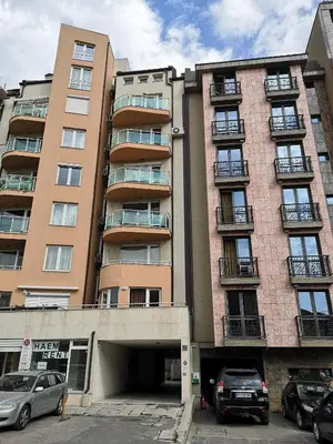 a tall building with a parking garage in front of it at Studio Talisman II in Sofia