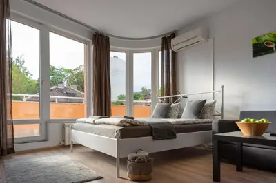 a bedroom with a bed and a large window at Studio Talisman II in Sofia