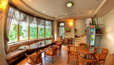 a restaurant with tables and chairs and a couch at Plaza Family Hotel in Smolyan