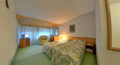 a hotel room with a bed and a television at Plaza Family Hotel in Smolyan