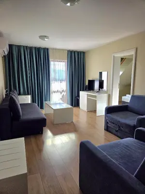 a living room with a couch and a table at Elegance Spa Hotel in Ognyanovo