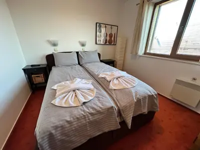 a bedroom with a large bed with two pillows on it at Private apartment in Prespa in Bansko