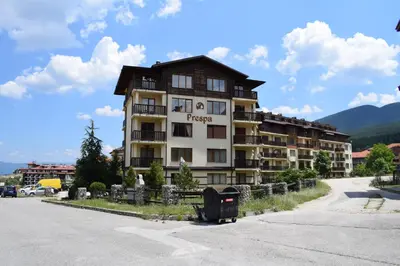 a large apartment building in front of a parking lot at Private apartment in Prespa in Bansko