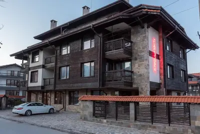 a building with a car parked in front of it at Charming, Fully-furnished, 2-bedroom apartment by Flat Mаnager in Bansko
