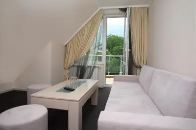 a living room with a white couch and a table at Family Hotel Diana in Sofia