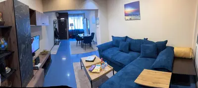 a living room with a blue couch and a table at KCT Downtown Apartment in Sofia