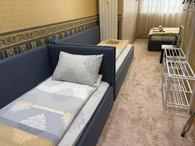 a room with two beds and a blue couch at KCT Downtown Apartment in Sofia
