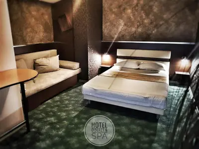 a hotel room with a bed and a couch at Discret Hotel & Restaurant in Vladaya