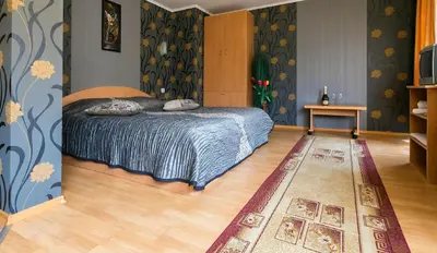 a bedroom with a bed and a rug at Discret Hotel & Restaurant in Vladaya